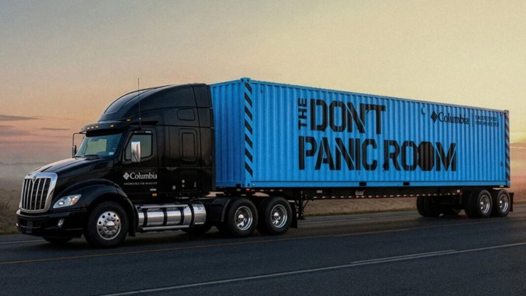 Columbia logolu siyah bir tırın çektiği, üzerinde “The Don’t Panic Room” yazan mavi konteyner