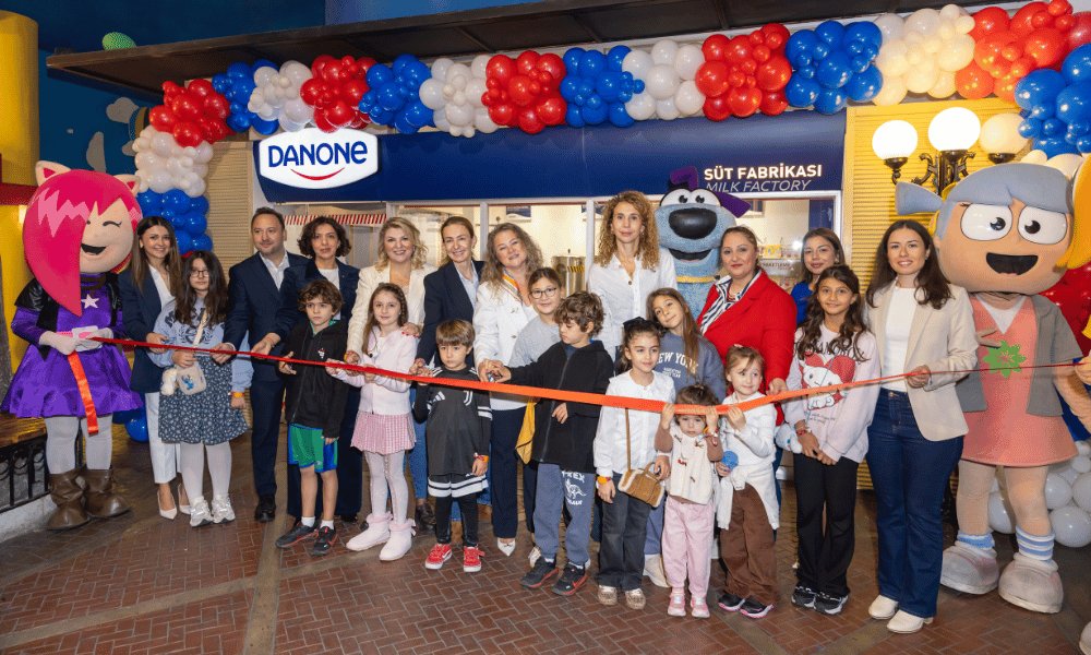KidZania İstanbul’daki Danone Süt Fabrikası alanının açılışında balonlarla süslü girişte maskotlar, çocuklar ve yetişkinlerin kurdele kesimi