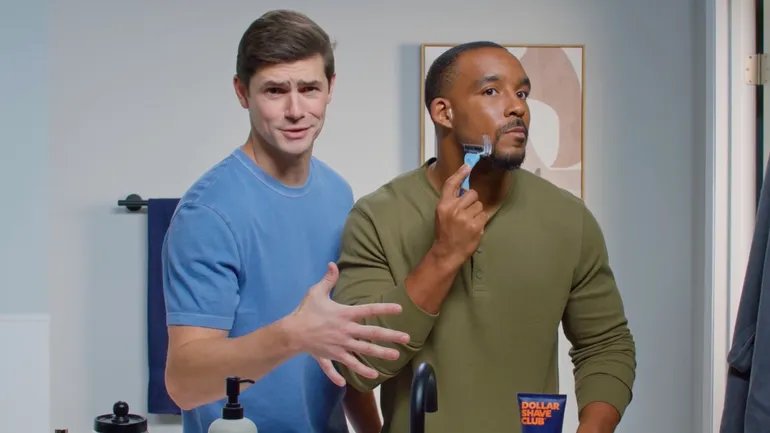 Dollar Shave Club reklamında banyoda tıraş makinesi gösteren iki erkek