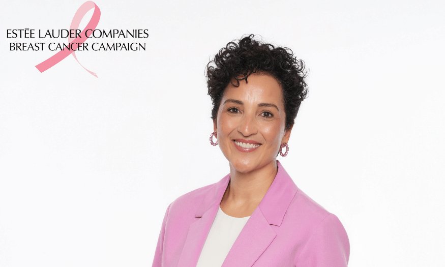 Pembe ceketli, kıvırcık saçlı gülümseyen Nazlı Koruyan Altıpat; sol üstte Estée Lauder Companies Breast Cancer Campaign logosu ve pembe kurdele