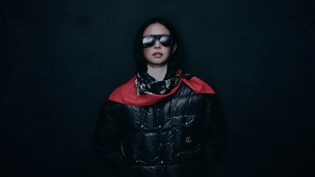 Moncler Re/Icons kampanyasında kırmızı yakalı siyah şişme mont ve güneş gözlüğüyle poz veren yıldız