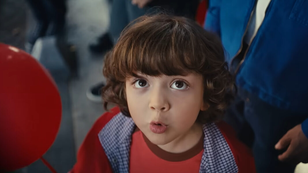 Şişecam’ın Cumhuriyet Bayramı reklam filminden bir kare: kırmızı balonların arasında yukarı bakan kıvırcık saçlı bir çocuk