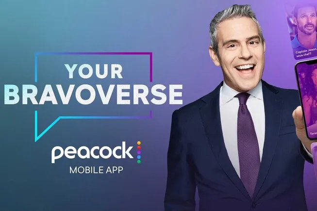 Peacock mobil uygulamasındaki Your Bravoverse deneyiminin tanıtım görselinde gülümseyen Andy Cohen ve telefon ekranı